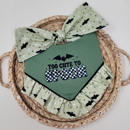 Green dog bandana with "Too Cute To Spook" text and ruffle trim with black bats.